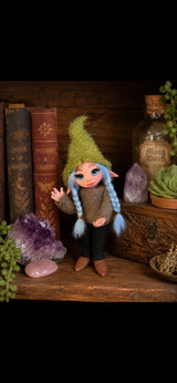 Nirea Pixie artesanal con trenzas azules entre cristales y libros de magia