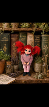 Ruvella Pixie artesanal con coletas rojas entre libros de botánica y flores secas